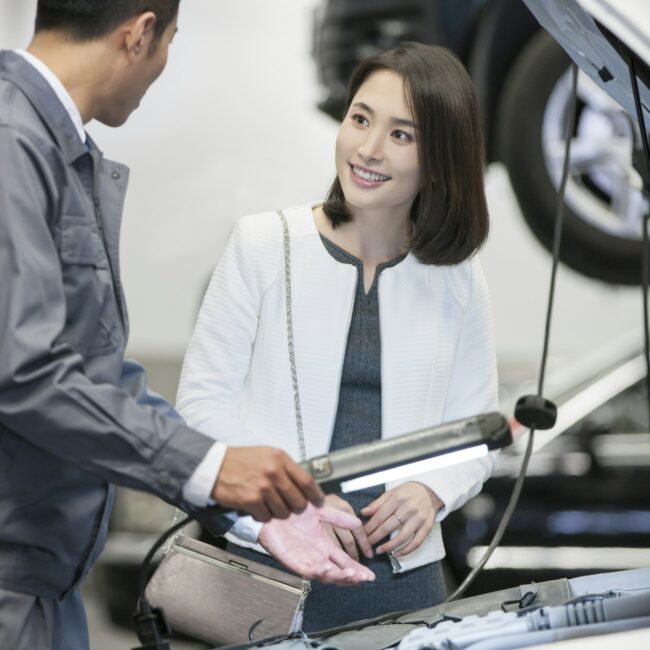 Auto mechanic talking with car owner